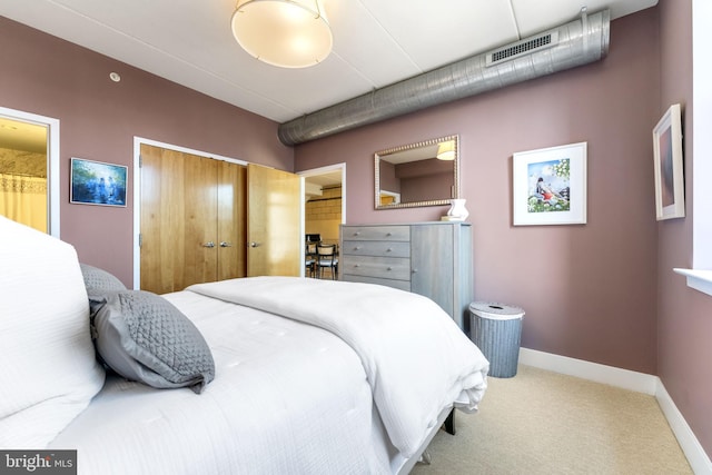 bedroom with a closet, carpet, baseboards, and ensuite bath