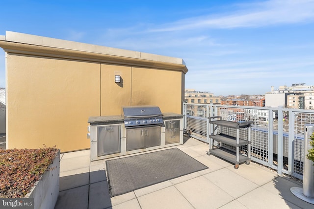 view of patio / terrace with grilling area, a balcony, and a view of city