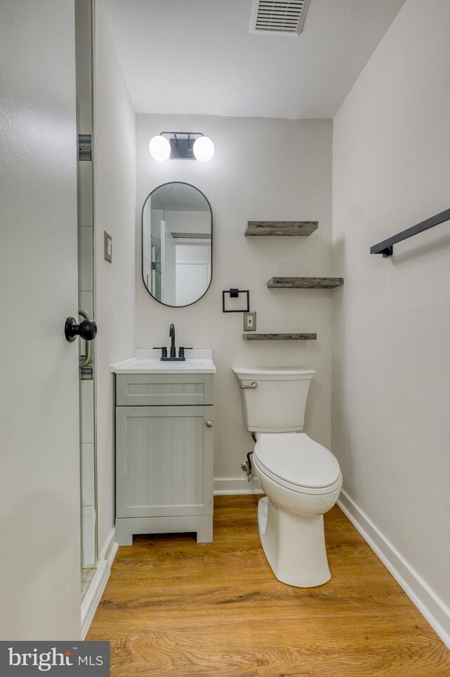 9815 Winands Rd, Randallstown, MD 21133 - bathroom featuring wood finished floors, toilet, baseboards, vanity, and an enclosed shower