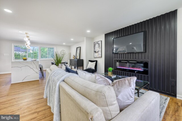 9815 Winands Rd, Randallstown, MD 21133 - living area with wood finished floors, baseboards, recessed lighting, a glass covered fireplace, and an accent wall