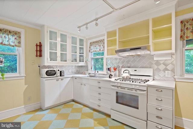 4901 40th Pl, Hyattsville, MD 20781 - kitchen featuring white appliances, under cabinet range hood, light floors, decorative backsplash, and plenty of natural light