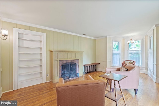 4901 40th Pl, Hyattsville, MD 20781 - living area with ornamental molding, a brick fireplace, built in shelves, wood finished floors, and a chandelier