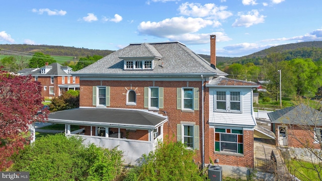 16 N Maple Ave, Smithsburg, MD 21783 - view of front of property featuring cooling unit, brick siding, a chimney, and a mountain view