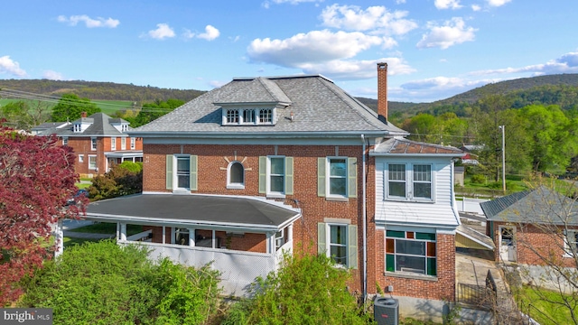 16 N Maple Ave, Smithsburg, MD 21783 - view of front of house featuring central AC unit, brick siding, a chimney, and a mountain view