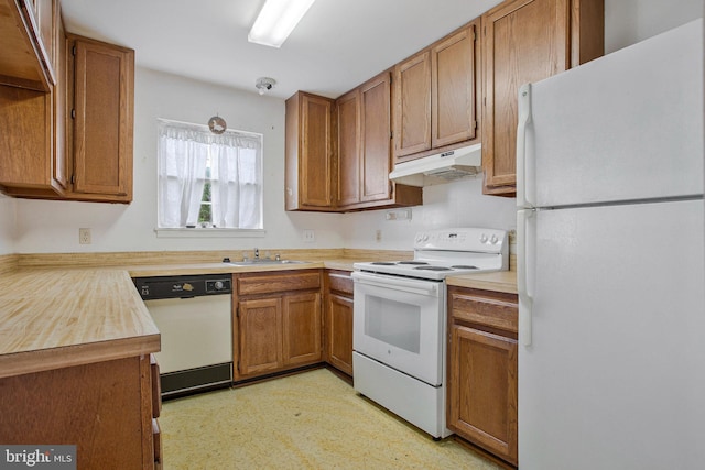 10734 Castleton Way, Upper Marlboro, MD 20774 - kitchen with white appliances, under cabinet range hood, a sink, brown cabinetry, and light countertops