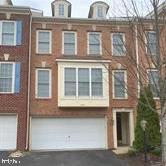 multi unit property featuring a garage and driveway