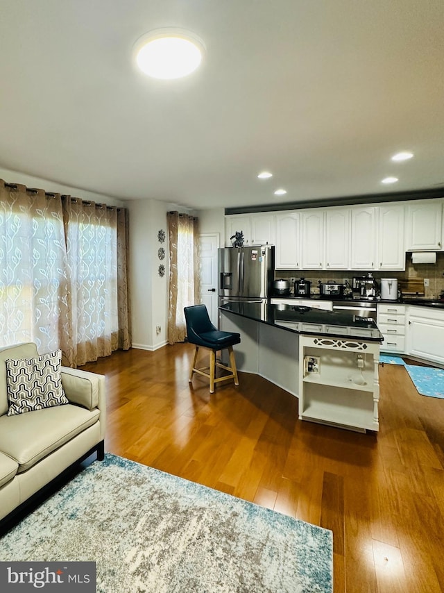 living room with dark wood-style floors and recessed lighting