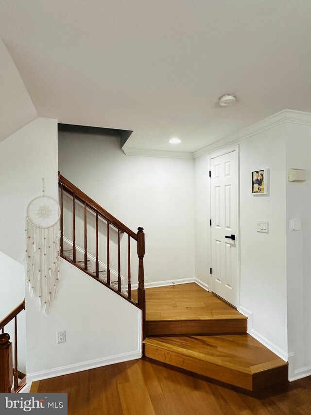 foyer with wood finished floors, baseboards, recessed lighting, and stairs
