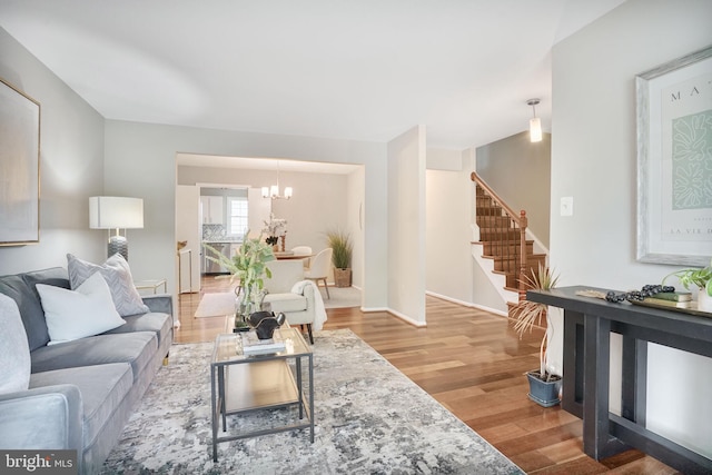 9807 Spillway Ct, Burke, VA 22015 - living room with a chandelier, stairs, light wood finished floors, and baseboards