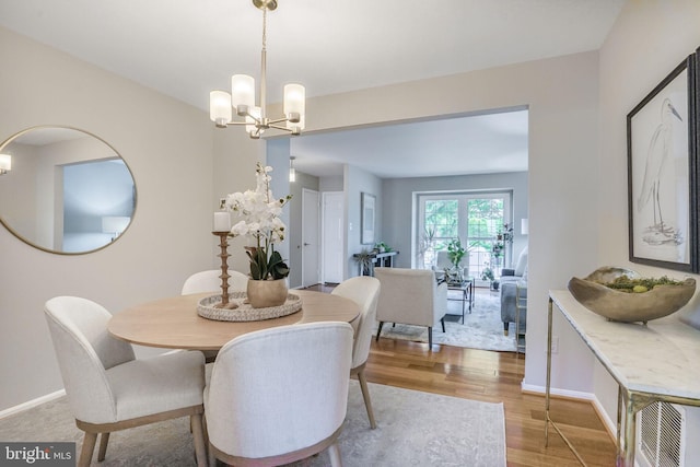 9807 Spillway Ct, Burke, VA 22015 - dining area featuring wood finished floors, a chandelier, and baseboards