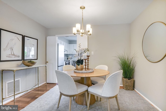 9807 Spillway Ct, Burke, VA 22015 - dining room featuring a chandelier, wood finished floors, and baseboards