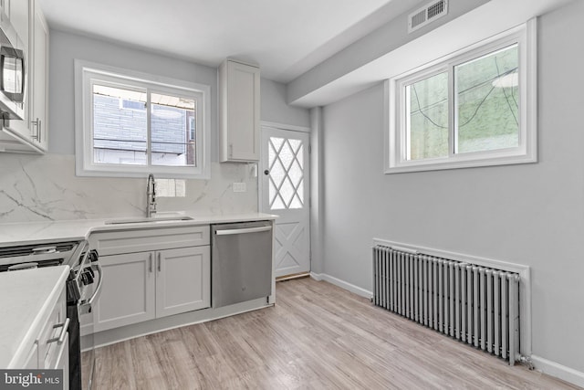 1906 Durfor St, Philadelphia, PA 19145 - kitchen featuring radiator heating unit, appliances with stainless steel finishes, a sink, and decorative backsplash
