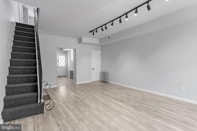 1906 Durfor St, Philadelphia, PA 19145 - unfurnished living room with stairs, rail lighting, light wood-style flooring, and baseboards