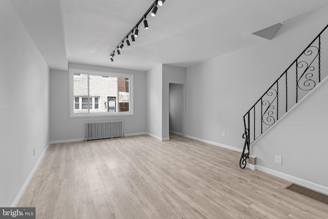 1906 Durfor St, Philadelphia, PA 19145 - unfurnished living room with radiator, track lighting, wood finished floors, and stairway