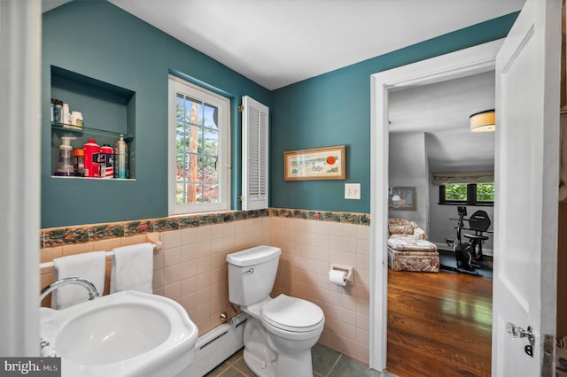 410 Arthurs Round Table, Wynnewood, PA 19096 - half bathroom with a sink, toilet, a baseboard heating unit, tile walls, and wainscoting