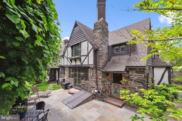 410 Arthurs Round Table, Wynnewood, PA 19096 - back of property featuring a patio, a shingled roof, a chimney, and central AC unit