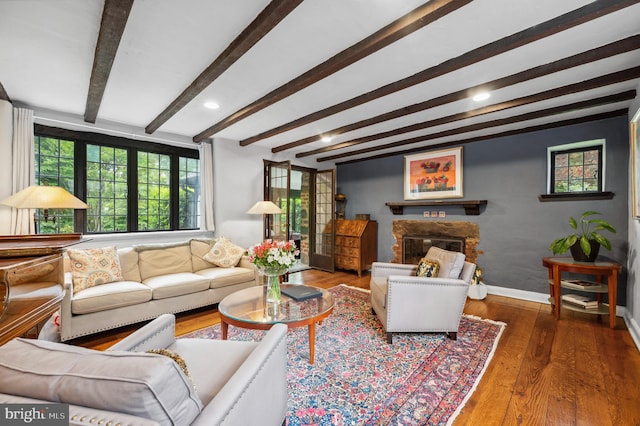 410 Arthurs Round Table, Wynnewood, PA 19096 - living room featuring beam ceiling, wood finished floors, a stone fireplace, and baseboards
