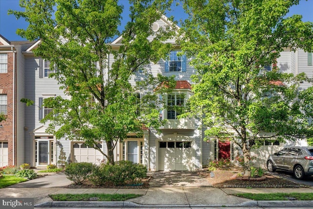 townhome / multi-family property with a garage and driveway