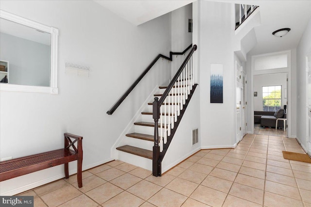 stairs featuring tile patterned floors and baseboards