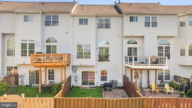 rear view of house with cooling unit and a fenced backyard