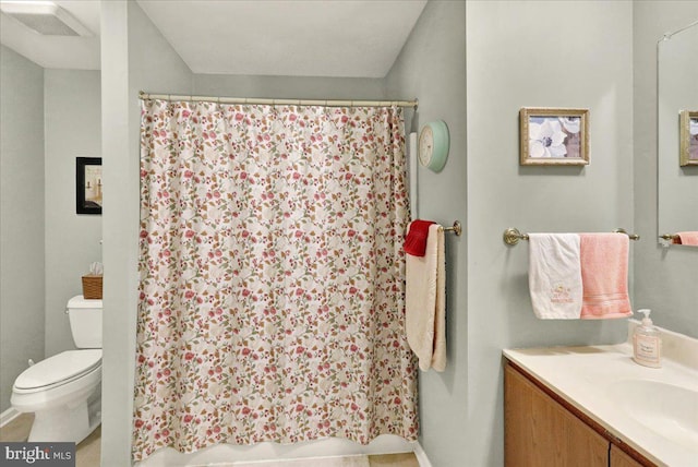 bathroom with toilet, vanity, a shower with curtain, and baseboards