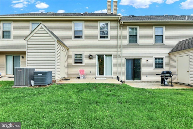 back of house featuring central air condition unit, a chimney, a patio, and a yard