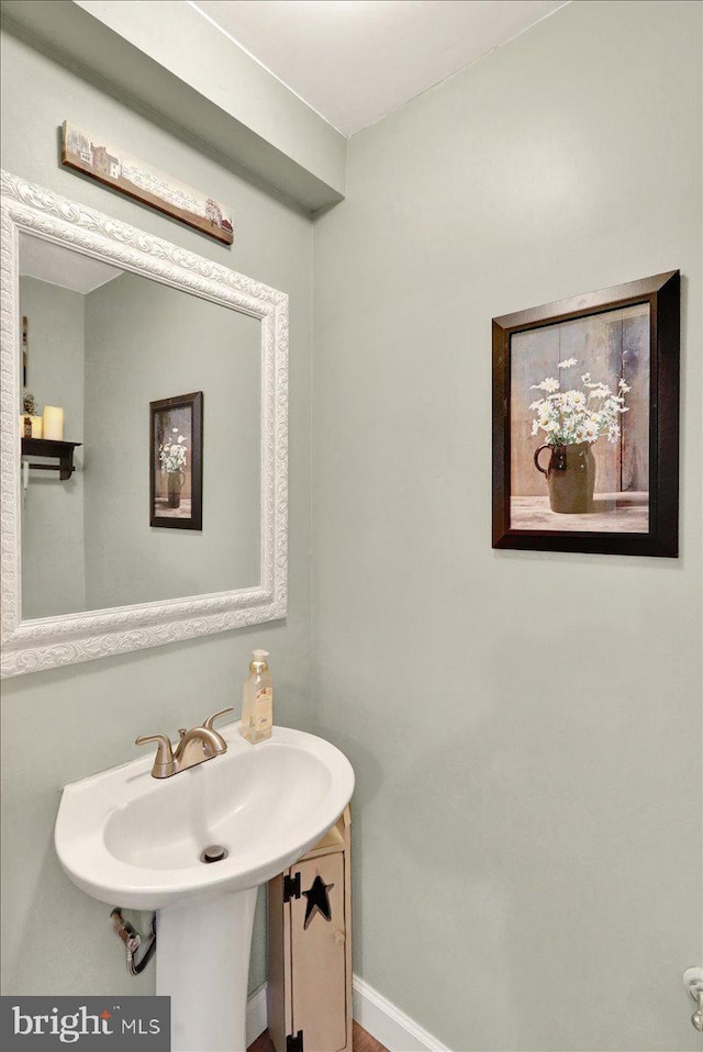 bathroom featuring baseboards and a sink
