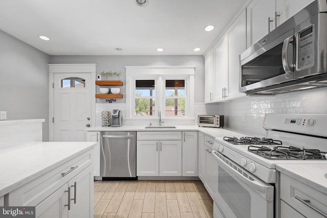 355 Agabiti Ct, Hamilton, NJ 08610 - kitchen featuring stainless steel appliances, a sink, backsplash, white cabinets, and light wood-type flooring