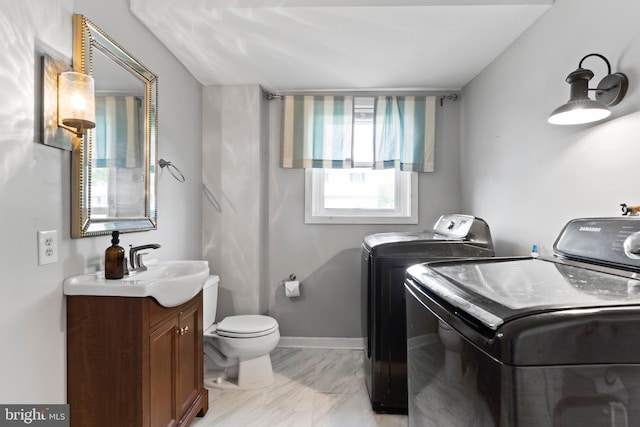 laundry area featuring washer and clothes dryer and light marble finish floors