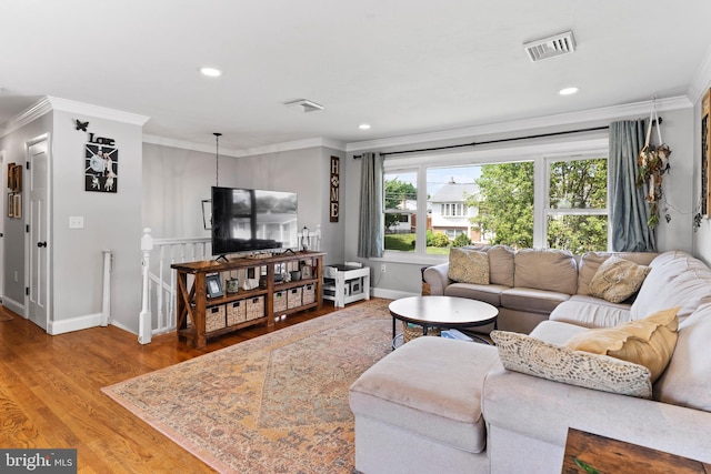 living area with baseboards, light wood finished floors, crown molding, and recessed lighting