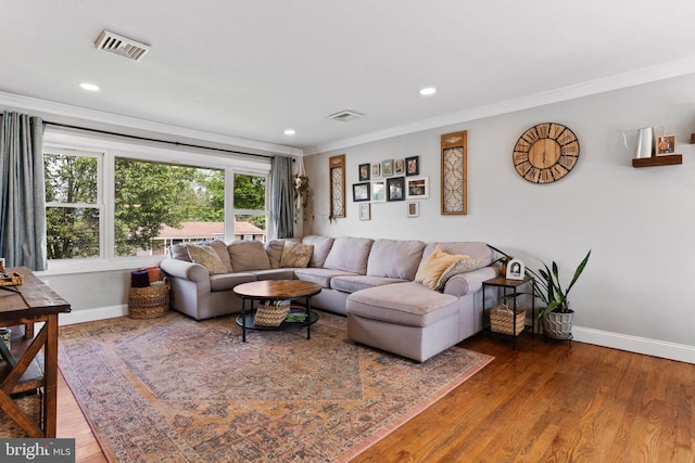 living area with baseboards, wood finished floors, crown molding, and recessed lighting