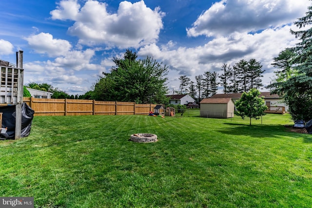 view of yard with a storage shed, an outdoor fire pit, and an outdoor structure
