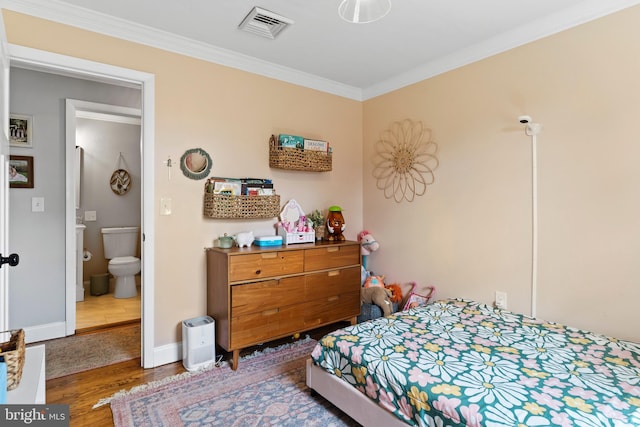 bedroom with wood finished floors, ornamental molding, and baseboards