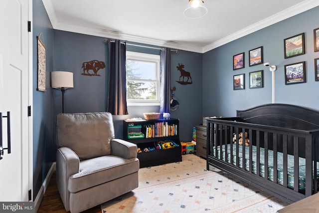bedroom with a crib and ornamental molding