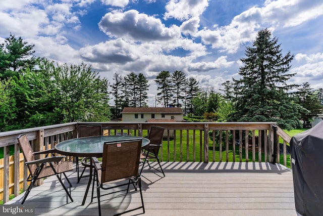 wooden deck featuring outdoor dining area and a grill
