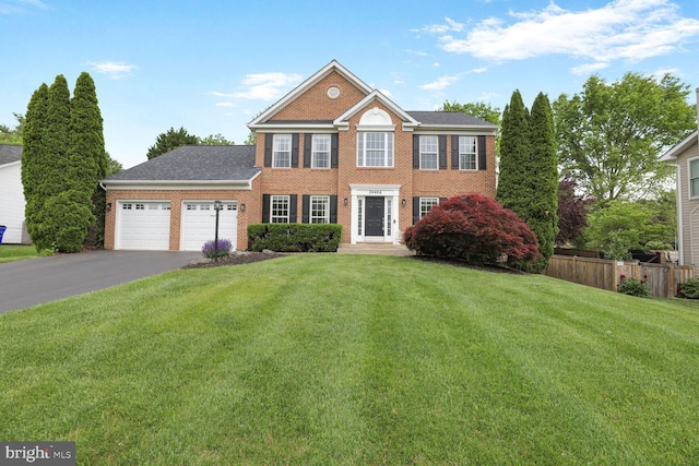 colonial home with brick siding, asphalt driveway, and an attached garage