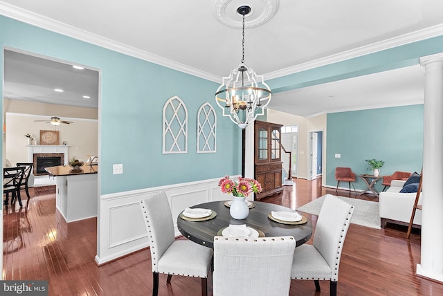 43127 Rocks Way, Leesburg, VA 20176 - dining area with crown molding, a glass covered fireplace, a chandelier, wood finished floors, and baseboards