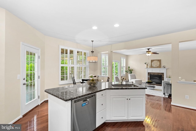 43127 Rocks Way, Leesburg, VA 20176 - kitchen featuring dishwasher, a sink, a glass covered fireplace, dark wood-style flooring, and dark stone countertops