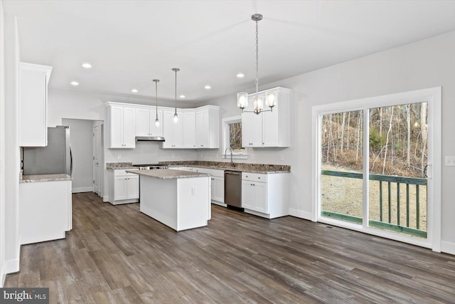 6741 Ginseng Ln, King George, VA 22485 - kitchen with stainless steel appliances, under cabinet range hood, white cabinets, a kitchen island, and recessed lighting