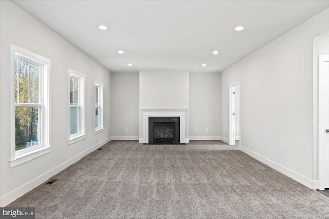 6741 Ginseng Ln, King George, VA 22485 - unfurnished living room with recessed lighting, healthy amount of natural light, carpet floors, a fireplace with flush hearth, and baseboards