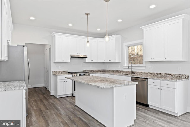 6741 Ginseng Ln, King George, VA 22485 - kitchen featuring stainless steel appliances, a sink, under cabinet range hood, white cabinetry, and wood finished floors