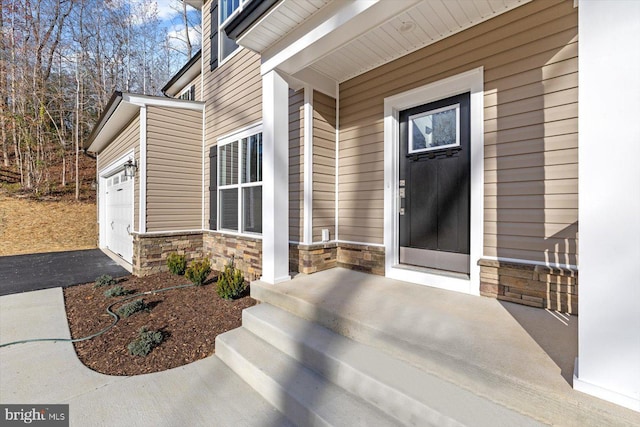 6741 Ginseng Ln, King George, VA 22485 - doorway to property with stone siding, an attached garage, and asphalt driveway