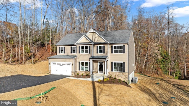 6741 Ginseng Ln, King George, VA 22485 - view of front facade featuring asphalt driveway, a garage, stone siding, central air condition unit, and a shingled roof