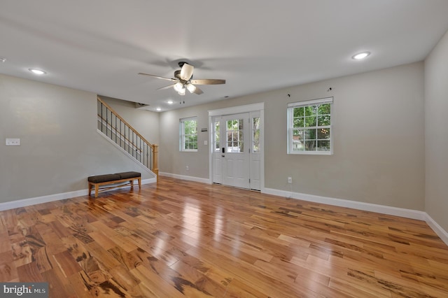 foyer with light wood-type flooring, a ceiling fan, stairs, baseboards, and recessed lighting