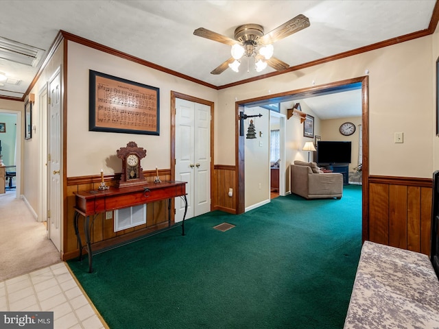 corridor with carpet, wainscoting, and crown molding