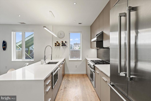 1932 9th St NW Unit R402, Washington, DC 20001 - kitchen featuring premium appliances, a sink, under cabinet range hood, modern cabinets, and recessed lighting
