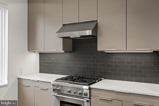 1932 9th St NW Unit R402, Washington, DC 20001 - kitchen featuring under cabinet range hood, high end range, light countertops, and tasteful backsplash