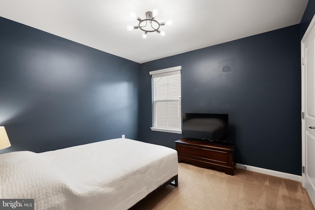 carpeted bedroom featuring baseboards and a chandelier