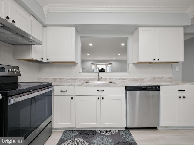 kitchen featuring appliances with stainless steel finishes, under cabinet range hood, a sink, crown molding, and white cabinetry