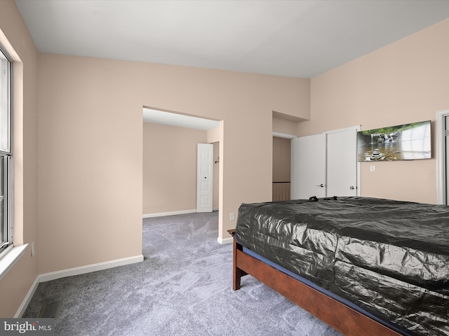 bedroom with carpet floors, vaulted ceiling, and baseboards